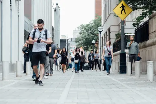 People walking on a street looking distracted with cell phones - not looking at each other