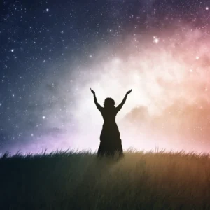 A woman looking up to the stars with her hands raised