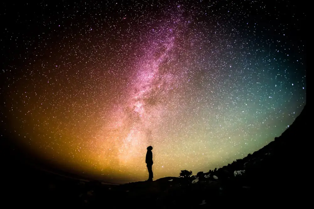 man looking up sky with  milky way background